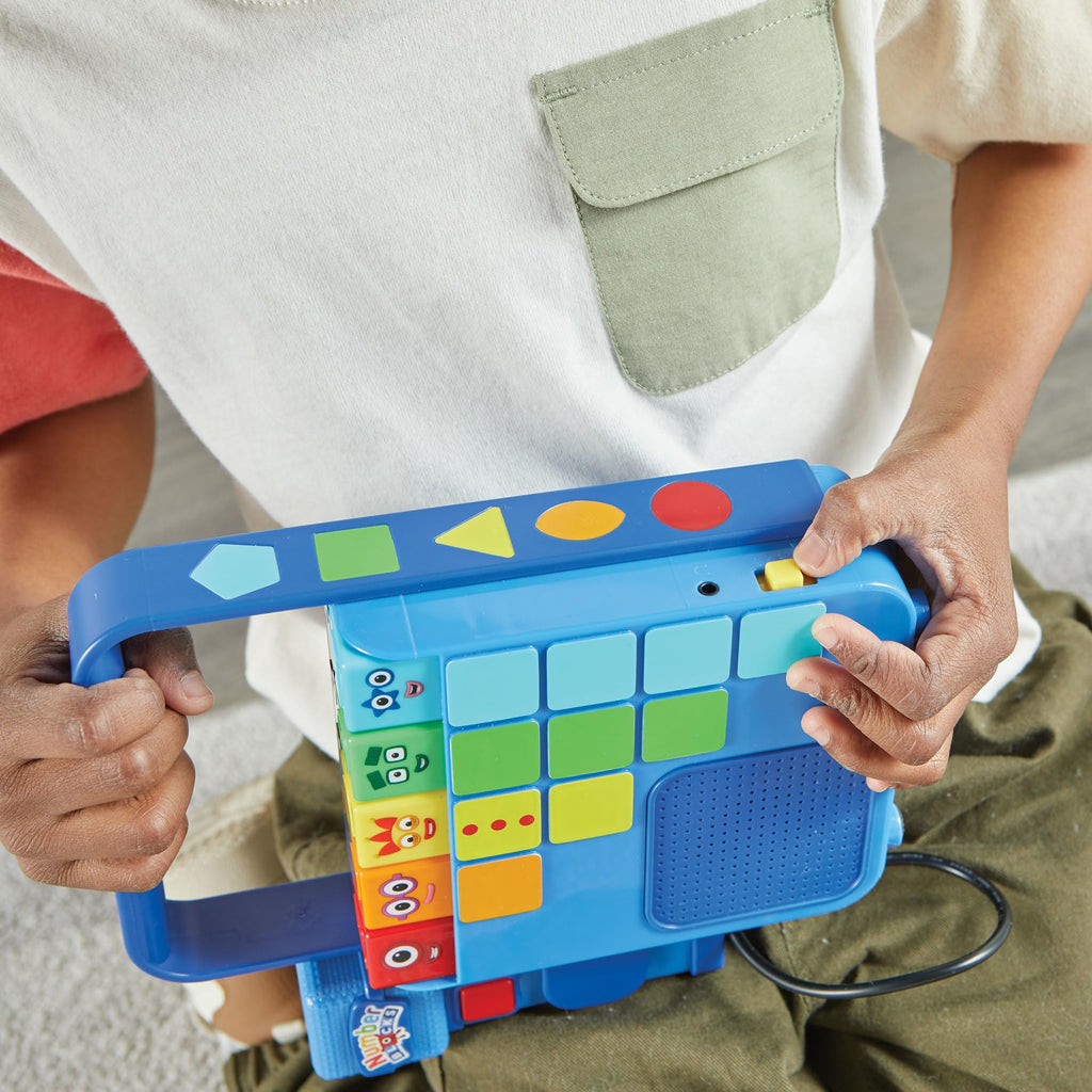 Hand2mind interactive musical toy being carried by the easy-grip handle for kids.