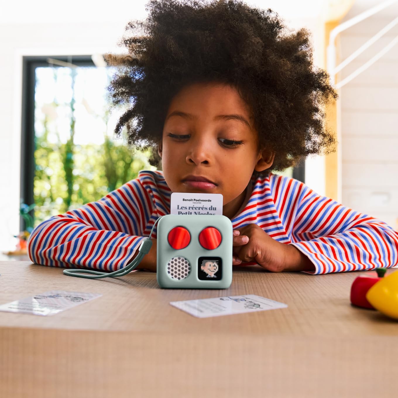 Kid friendly physical audio soundtrack card being inserted into a compact travel speaker system.