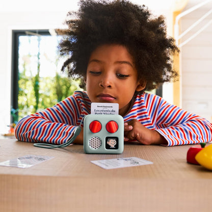 Kid friendly physical audio soundtrack card being inserted into a compact travel speaker system.