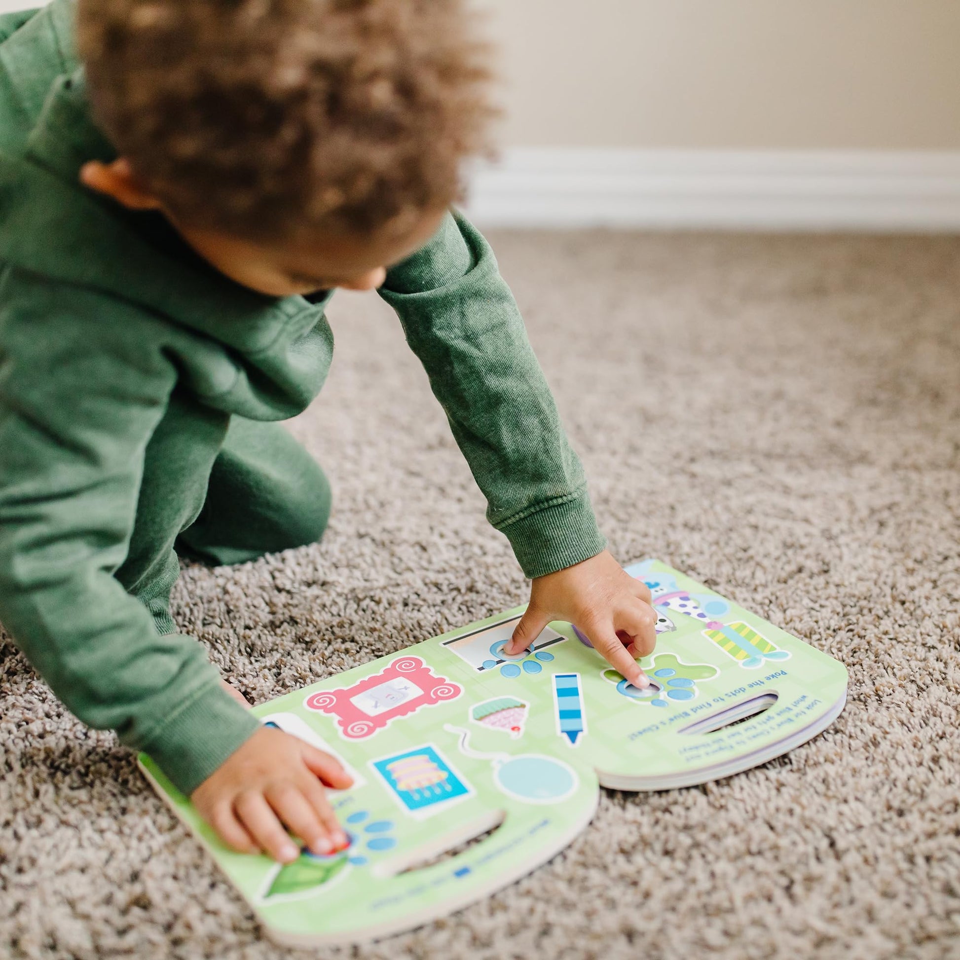 Preschooler playing with the Poke-A-Dot interactive shapes book
