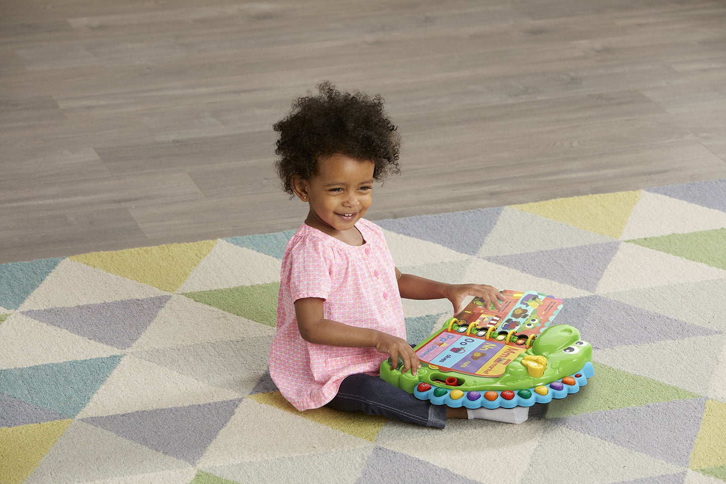 Toddler playing with LeapFrog Dino's Delightful Day book interactive buttons