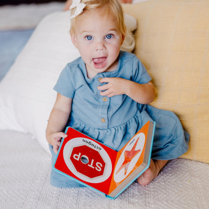 Detailed view of child pressing pop-buttons on board book page
