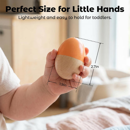 Toddler hand holding a green and yellow striped premium wood musical percussion egg rattle