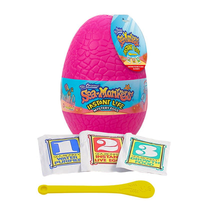 Sea-Monkeys hatching kit showing the three labeled step packets and yellow feeding spoon