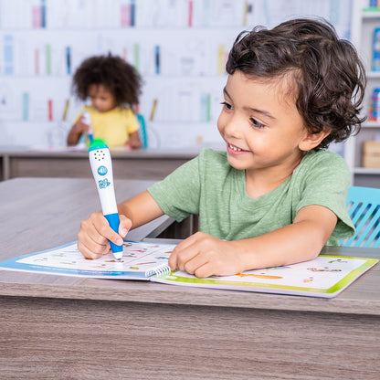 Preschool child using the green light-up interactive pen on the Hot Dots activity book pages