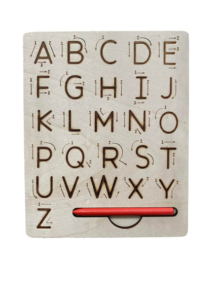 Toddler practicing pencil grip and alphabet formation using the wooden stylus on the grooved board