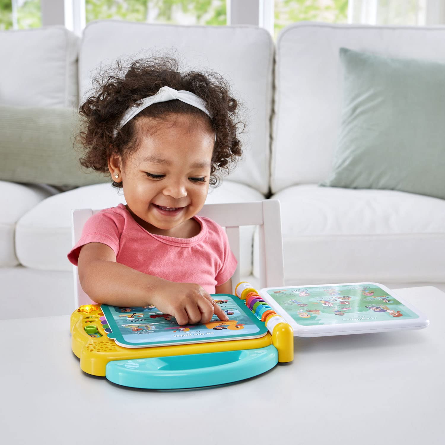 LeapFrog educational bilingual book rear view showcasing the secure battery compartment and volume controls.