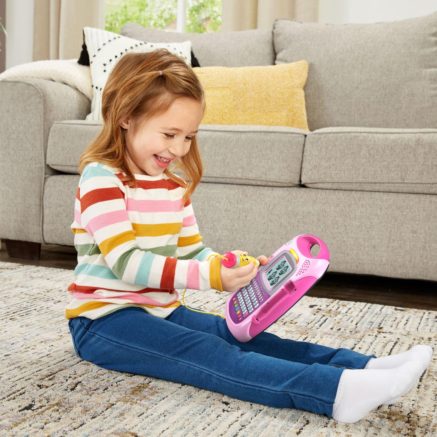 Preschool educational toy with pink frame showing animated letter tracing screen