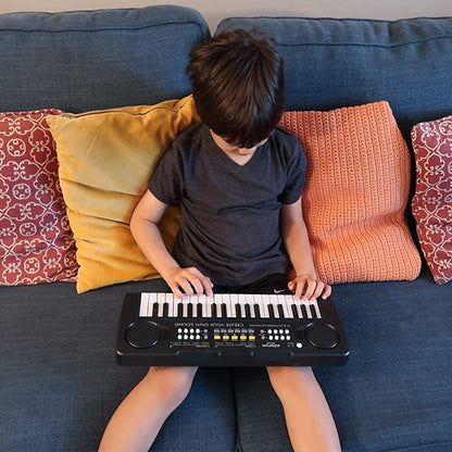 Kavana portable electronic toy piano set up on a flat table with included accessories