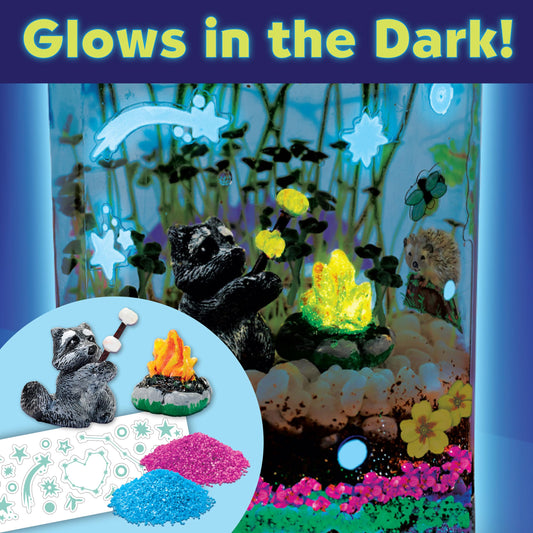 Assembled plastic mason jar terrarium filled with growing green wheatgrass sprouts, glowing sand layers, and miniature animal figurines.