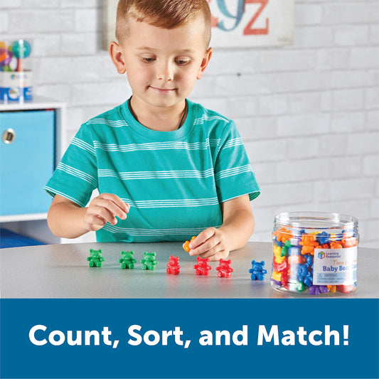 Six different colors of plastic teddy bear counters spread out on a white background