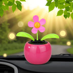 Solar powered swinging animated bobblehead flower sitting on a sunny office desk.