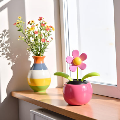 Xinjincang solar dancing toy in a colorful pot under direct sunlight.