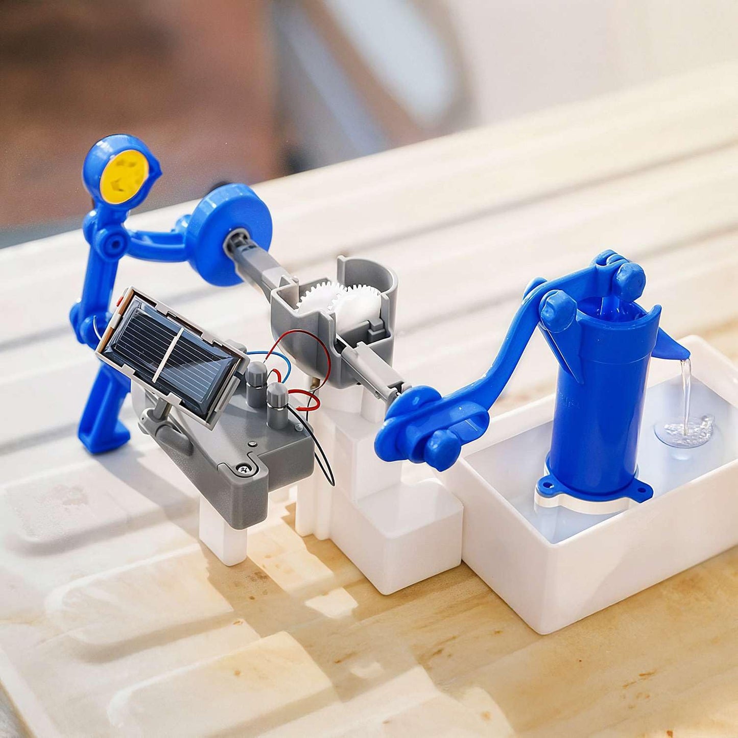 4M Green Science Solar Hybrid Water Pump toy working in a container of water showing the blue figure