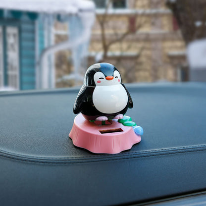 Compact mini penguin dancing doll placed on a clean vehicle dash surface