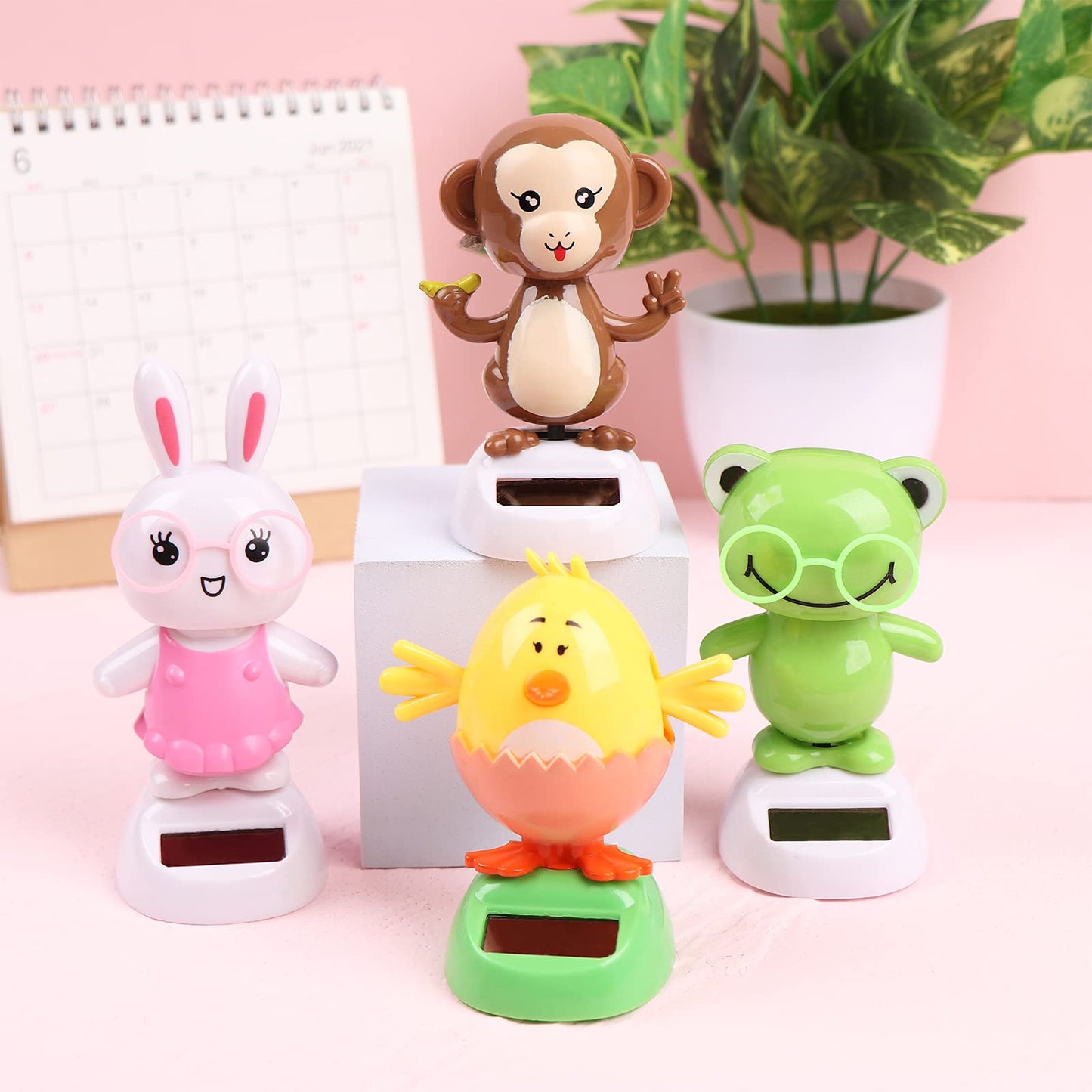 Welecom swinging rabbit dashboard figurine moving under bright office desk lighting.