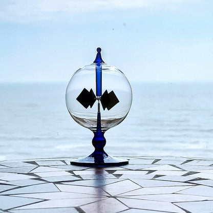 Handmade high boron tinted blue glass radiometer standing on a window sill in natural sunlight