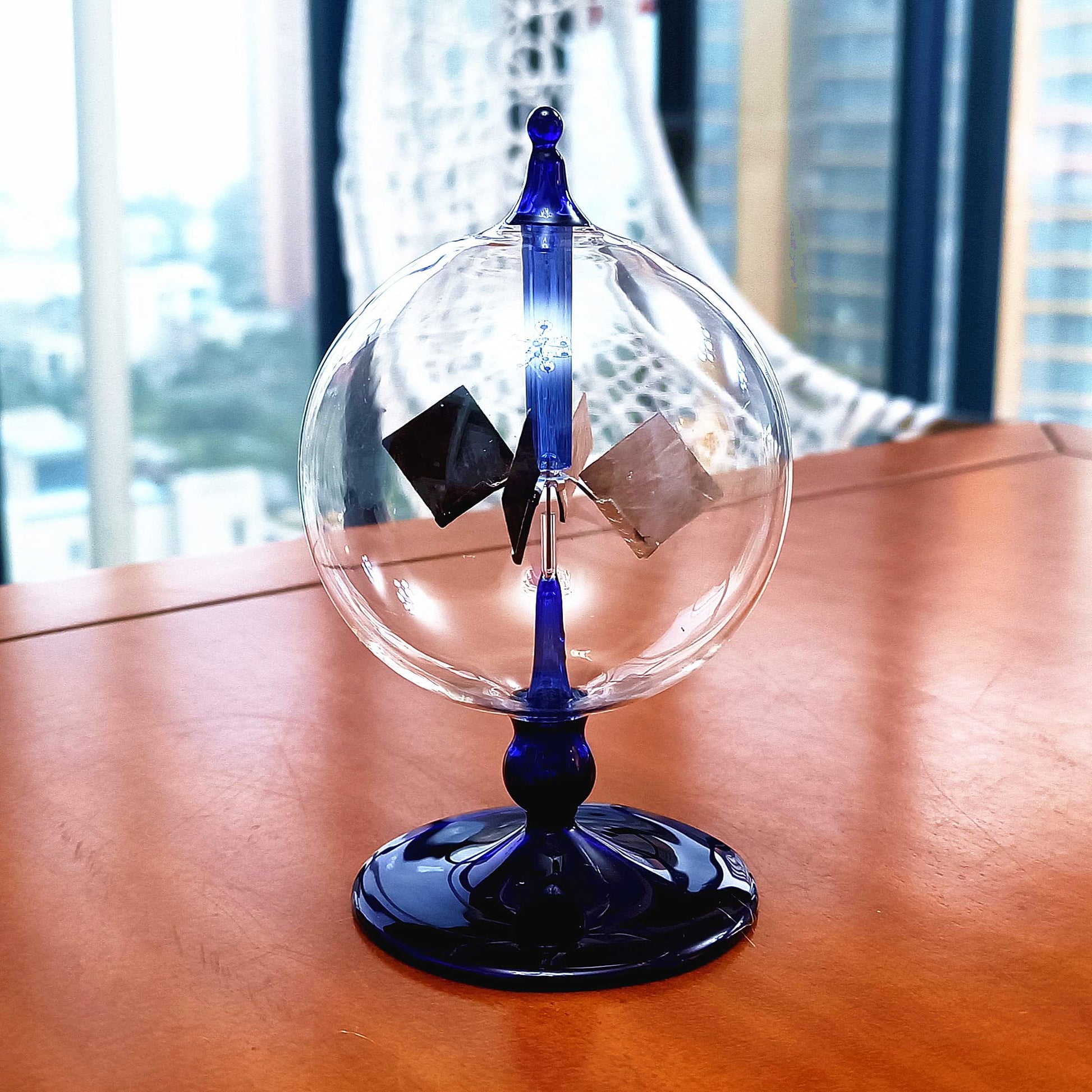 Small blue Crookes radiometer gift piece showcasing its unique vacuum bulb architecture