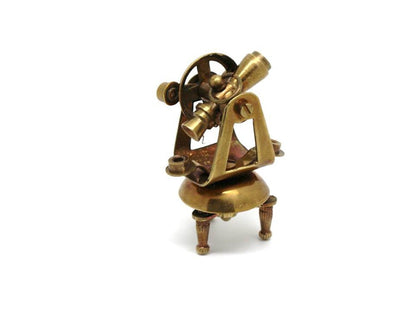 Detailed close up of miniature brass sextant and ship telegraph from the vintage collectible set
