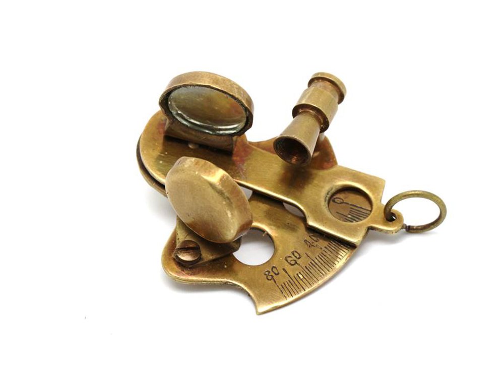 Steampunk decor arrangement featuring five miniature nautical reproduction instruments on a bookshelf