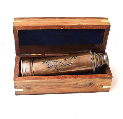 Side angle view of the collapsed 7 inch vintage copper telescope resting beside its gift box.