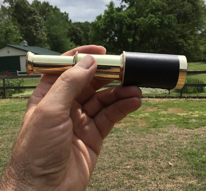 Three quarter angle of the vintage pirate spyglass showing the delicate engravings and metallic luster.