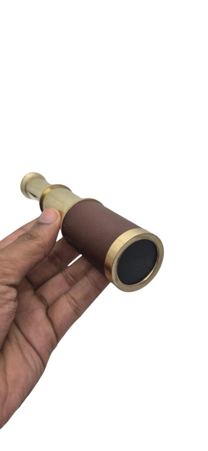 Prime Nautical brass telescope being adjusted for focus in an outdoor setting
