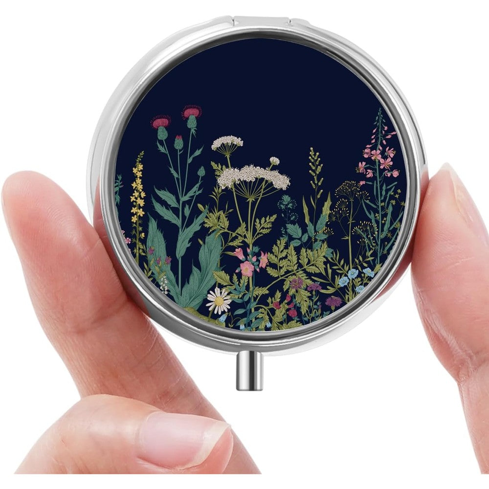 HCYPCV mini pill box front view showing the vintage black flowers decorative pattern on the metal shell.