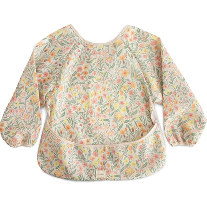 Mushie long sleeve baby bib front view in pastel blooms floral design