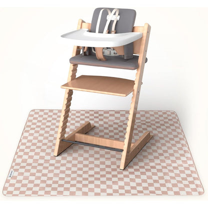Tiny Twinkle splat mat beige checkers front view spread out under a baby high chair on a wooden floor