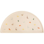 Mushie silicone placemat for kids front view showing dinosaur pattern on table mat