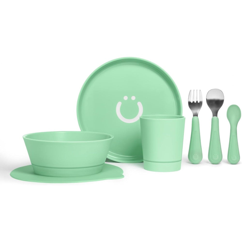 Ubbi Toddler Feeding Set 7 Piece front view showing green plate bowl cup and utensils with suction base