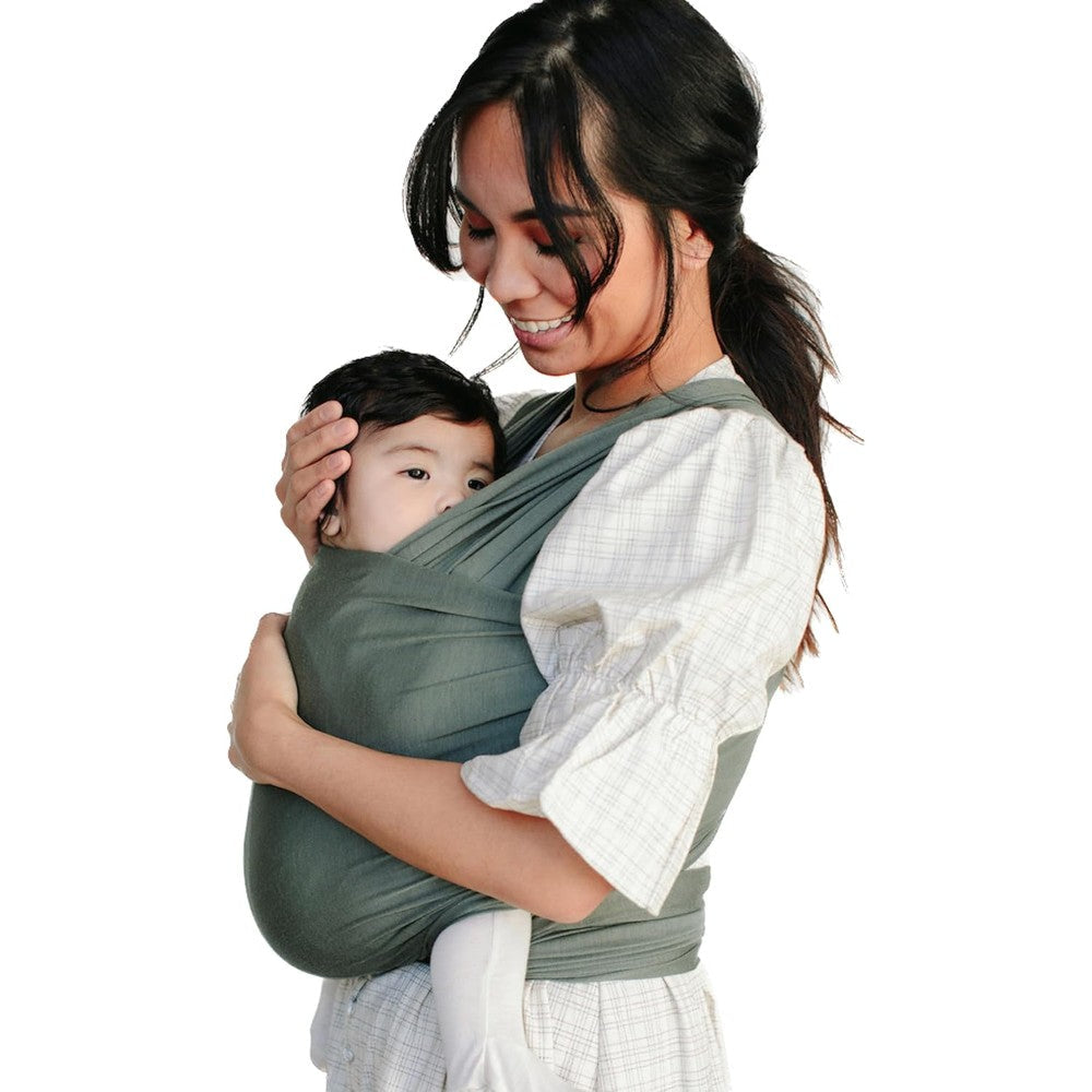 Solly Baby Wrap in Basil front view worn by a mother carrying her newborn infant.