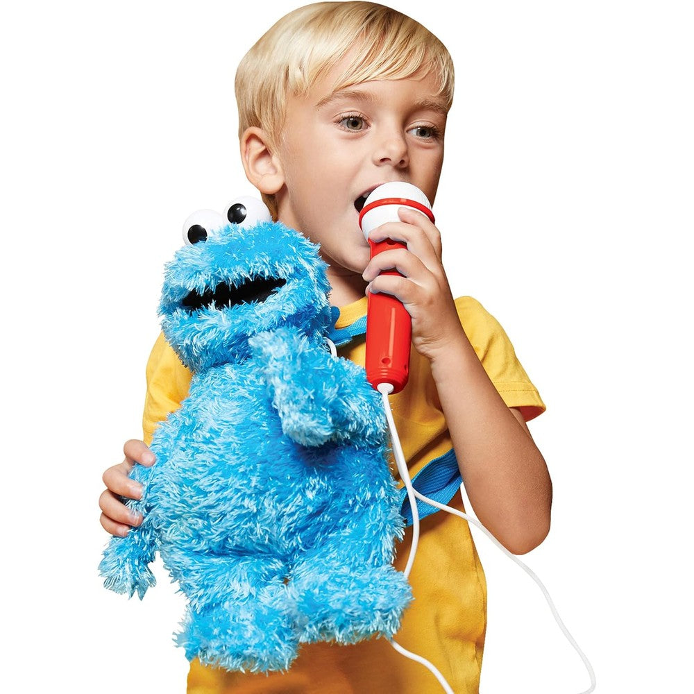 Singing Machine Cookie Monster karaoke plush toy front view showing blue fuzzy material and wired microphone.