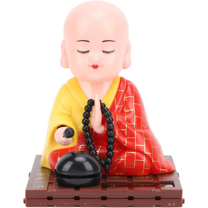 Tyenaza Little Monk Figurine front view showing red robe and solar panel on car dashboard.