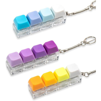 Gliging keyboard fidget toy pack showing three gradient keychains in purple, yellow, and blue macro view.