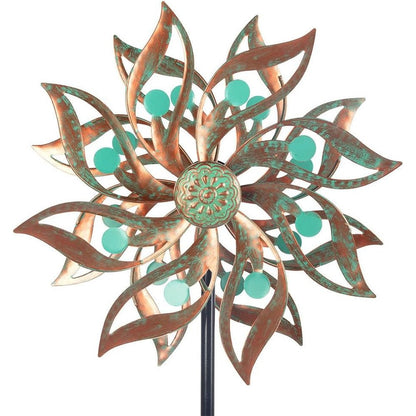 Viveta metal wind spinner front view displaying the vintage copper floral blades and green bead accents in a garden.